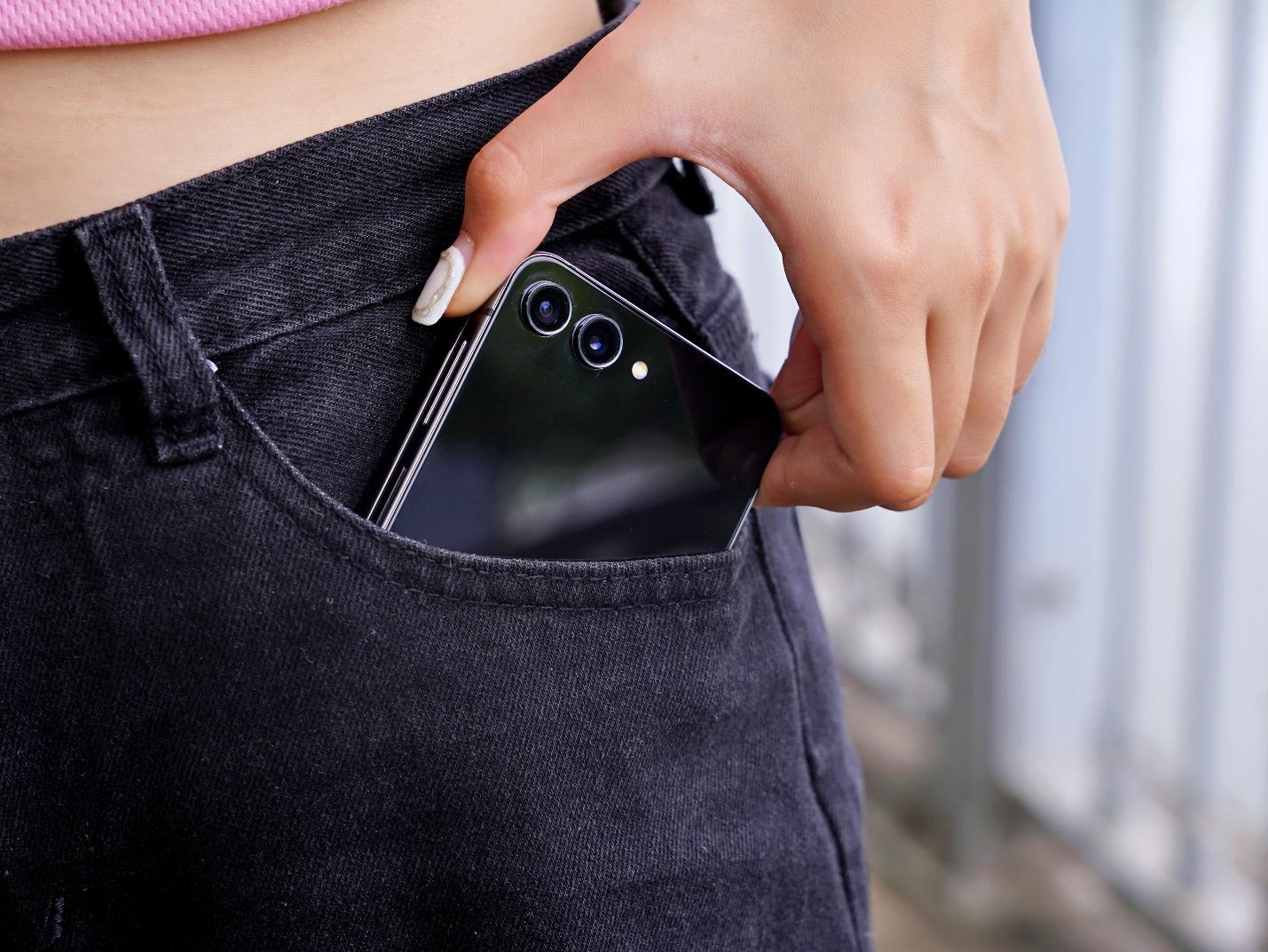 A person putting a phone in the pocket of their pantsDescription automatically generated